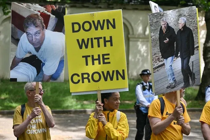 Anti-monarchy protesters in yellow shirts holding