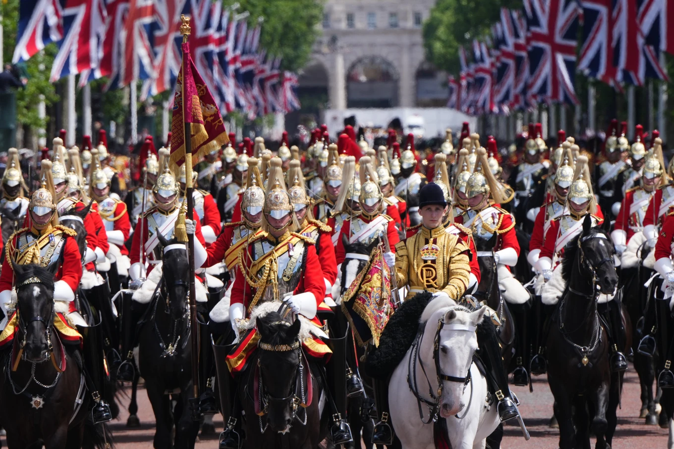 The Household Cavalry in full ceremonial uniform on horseback processing down The Mall lined with Union Jack flags at Trooping the Colour.