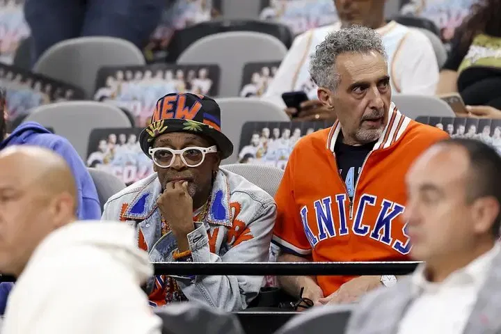 Spike Lee and John Turturro sitting courtside together at a New York Knicks game.