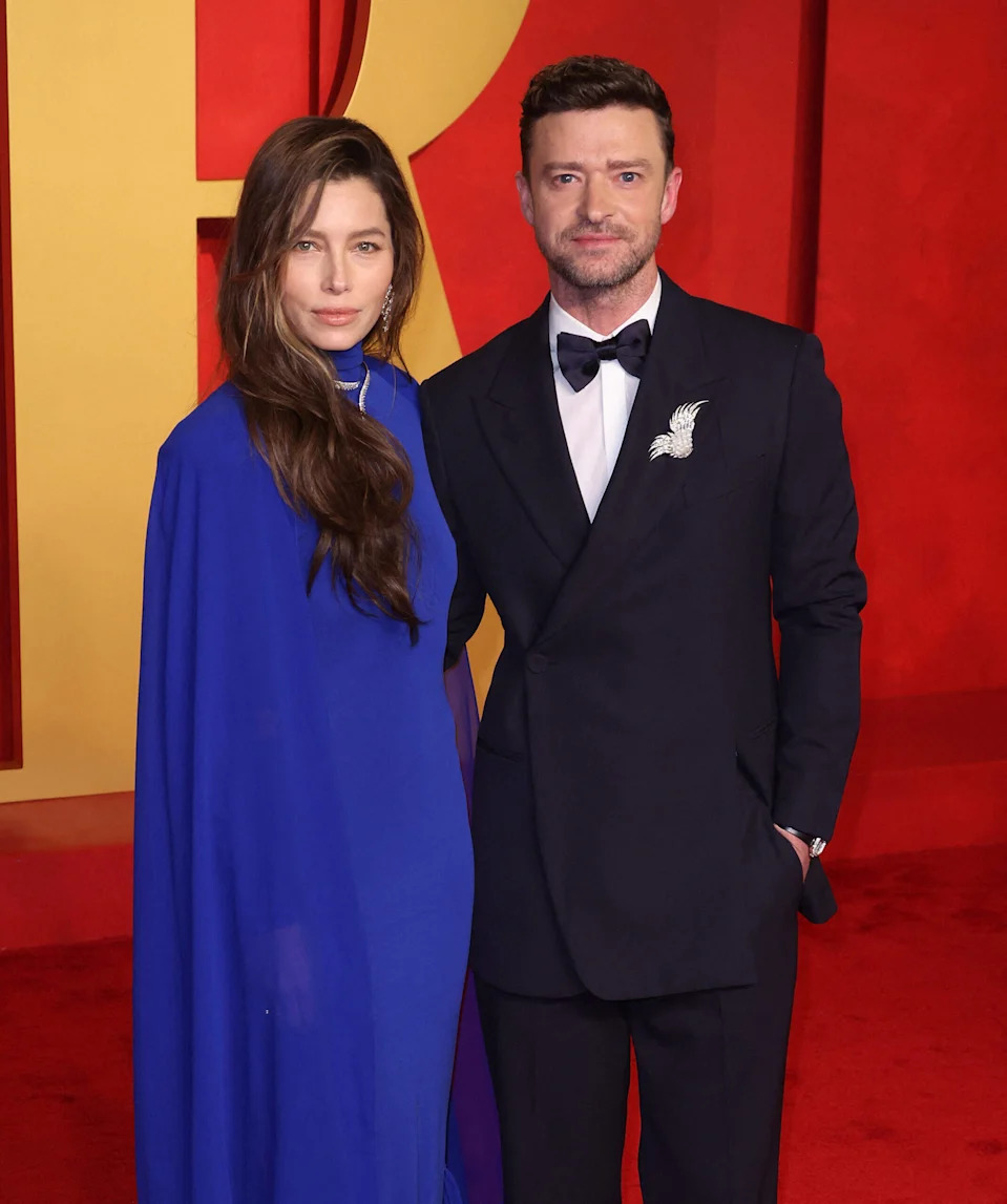 Jessica Biel and Justin Timberlake posing on a red carpet in front of a red and yellow backdrop at a formal event.