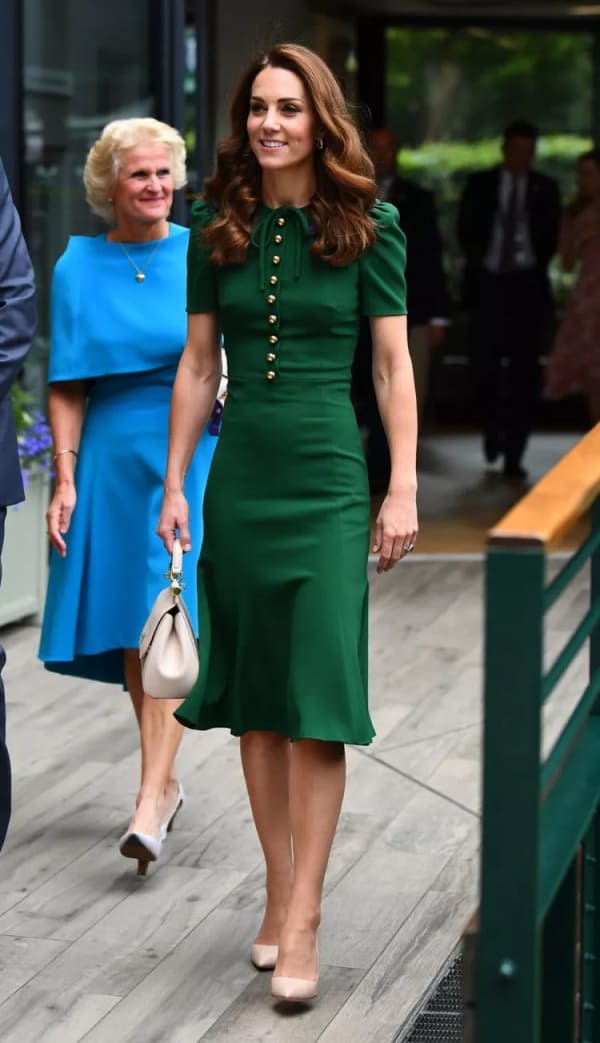 At Wimbledon's 2019 Ladies' Singles Final, she wore a custom forest green Dolce & Gabbana dress — fitted through the bodice, with gold buttons, a tied bow and puff sleeves — paired with ivory heels. | Photo: Getty Images
