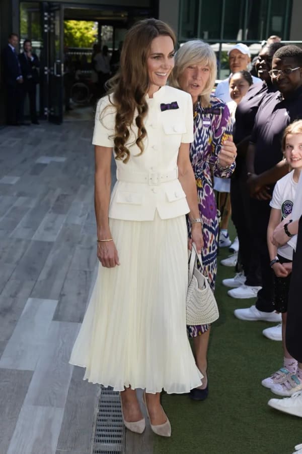 For the 2025 Ladies' Singles Final at Wimbledon, she wore a bespoke cream Self-Portrait midi co-ord: a structured belted jacket over a pleated skirt, finished with a purple and green patron's pin. | Photo: Getty Images