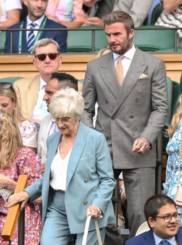 David Beckham attended Wimbledon's opening day with his mother, Sandra, cutting a sharp figure in a brown wool double-breasted suit paired with a gold tie.