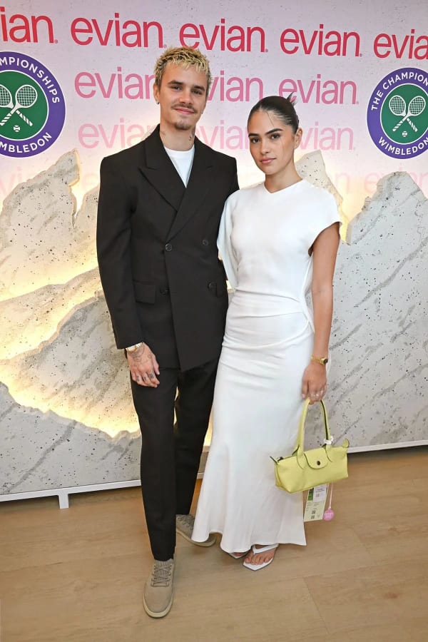 Romeo Beckham kept it casual-smart in a brown double-breasted suit over a T-shirt, while girlfriend Kim Turnbull wore a white Victoria Beckham dress finished with a yellow Longchamp bag and Dune heels.