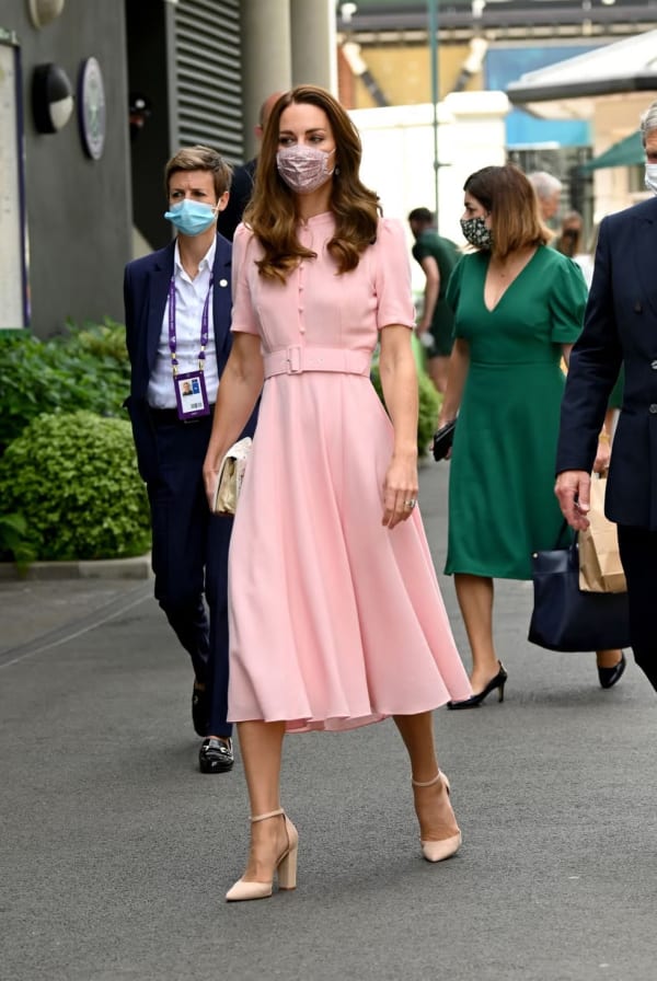 For the 2021 men's singles final, she wore a pale pink belted Beulah London midi dress — a soft contrast against a co-ordinating floral face mask that became an unexpectedly charming pandemic-era accessory. | Photo: Getty Images