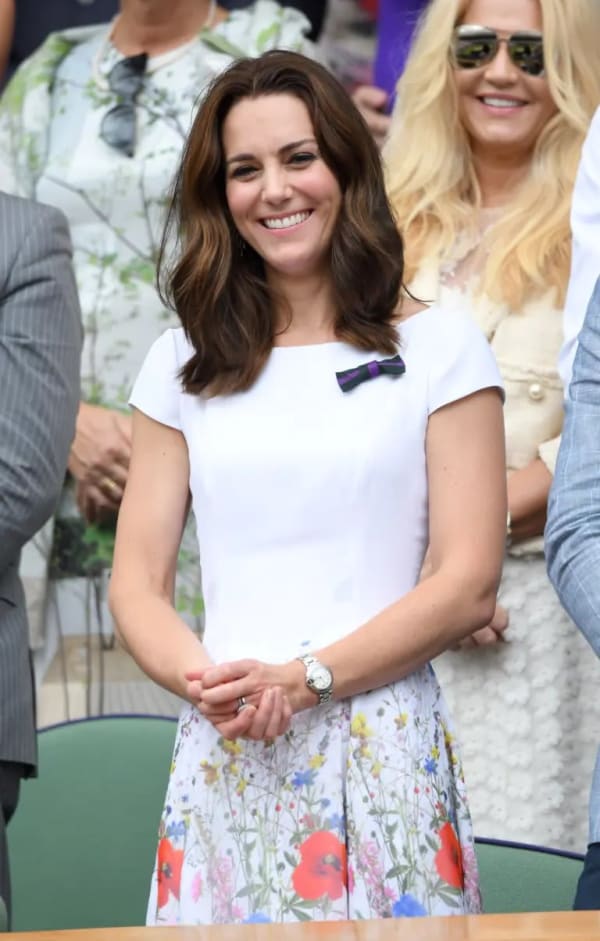 In 2017 — her first Wimbledon as club patron — she opted for a white Ted Baker dress with a vivid poppy-print border on the pleated skirt, wearing her purple-and-green AELTC bow pin with quiet pride from the Royal Box. | Photo: WireImage