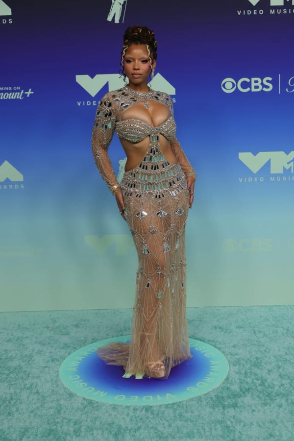 Chloe Bailey turned heads at the 2026 MTV VMAs at Los Angeles' Peacock Theater in a dazzling House of Idan crystal and mirror-embellished gown featuring geometric cutouts and a sheer floor-length skirt.