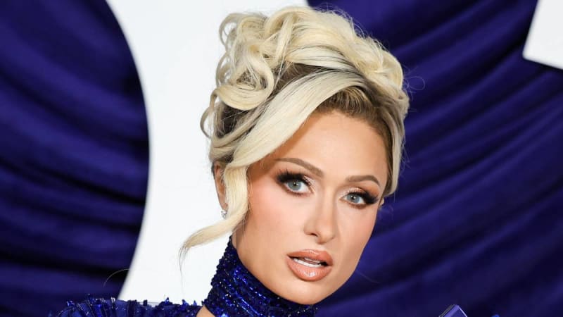 Paris Hilton in a blue sequined gown with an elegant updo at a glamorous event.