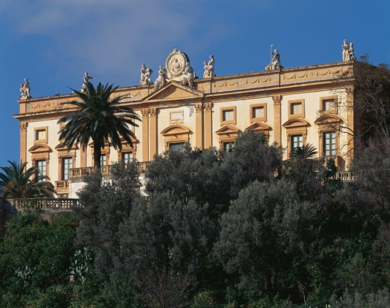 A large villa with trees in the foreground