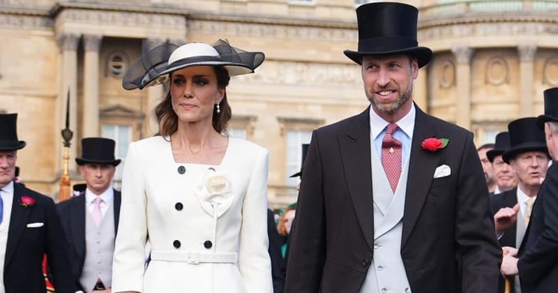 A man and woman in formal attire and top hats stand together at an elegant outdoor event near a grand classical building.