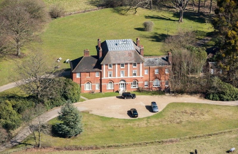 Aerial view of Forest Lodge, formerly known as Holly Grove in Windsor Great Park, Berkshire, 2018. A large red brick Georgian mansion with manicured grounds, circular driveway, and parked cars.
