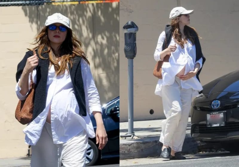 Elizabeth Olsen visibly pregnant, wearing a white shirt, cream trousers, dark vest and white cap, spotted outdoors in Los Angeles.