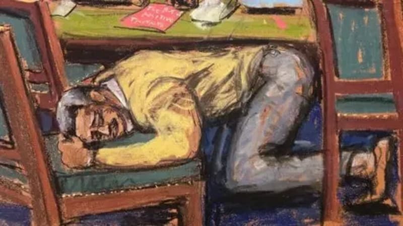Court sketch of Sean "Diddy" Combs slumped over a courtroom table in a yellow shirt and jeans after hearing his sentence.