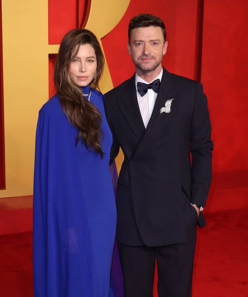 Jessica Biel and Justin Timberlake posing on a red carpet in front of a red and yellow backdrop at a formal event.
