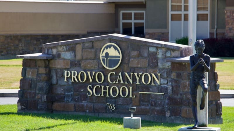 Provo Canyon School's stone entrance sign with address 763, featuring a logo and statue on the right side.