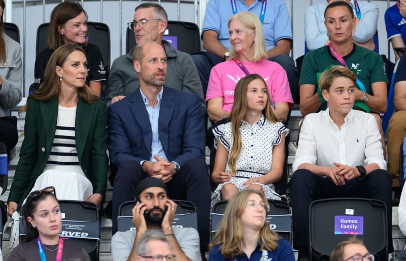 A family watches an event from the stands at what appears to be a sporting venue or arena.
