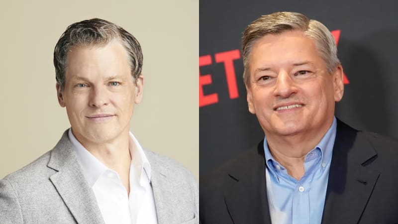On the left, a man with salt-and-pepper hair wearing a light grey blazer over a white open-collar shirt poses against a beige studio backdrop; on the right, an older man with short grey hair wearing a dark blazer over a light blue button-up shirt smiles in front of a Netflix-branded backdrop.