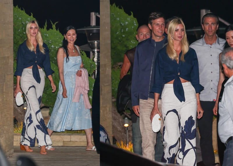 Left panel: a blonde woman in a navy tied blouse and wide-leg printed trousers walks alongside a dark-haired woman in a light blue sundress carrying a pink cardigan, on a wooden deck at night with greenery behind them. Right panel: the same blonde woman walks with a tall man in a navy zip jacket and khaki trousers, with several other people visible behind them in an outdoor nighttime setting.