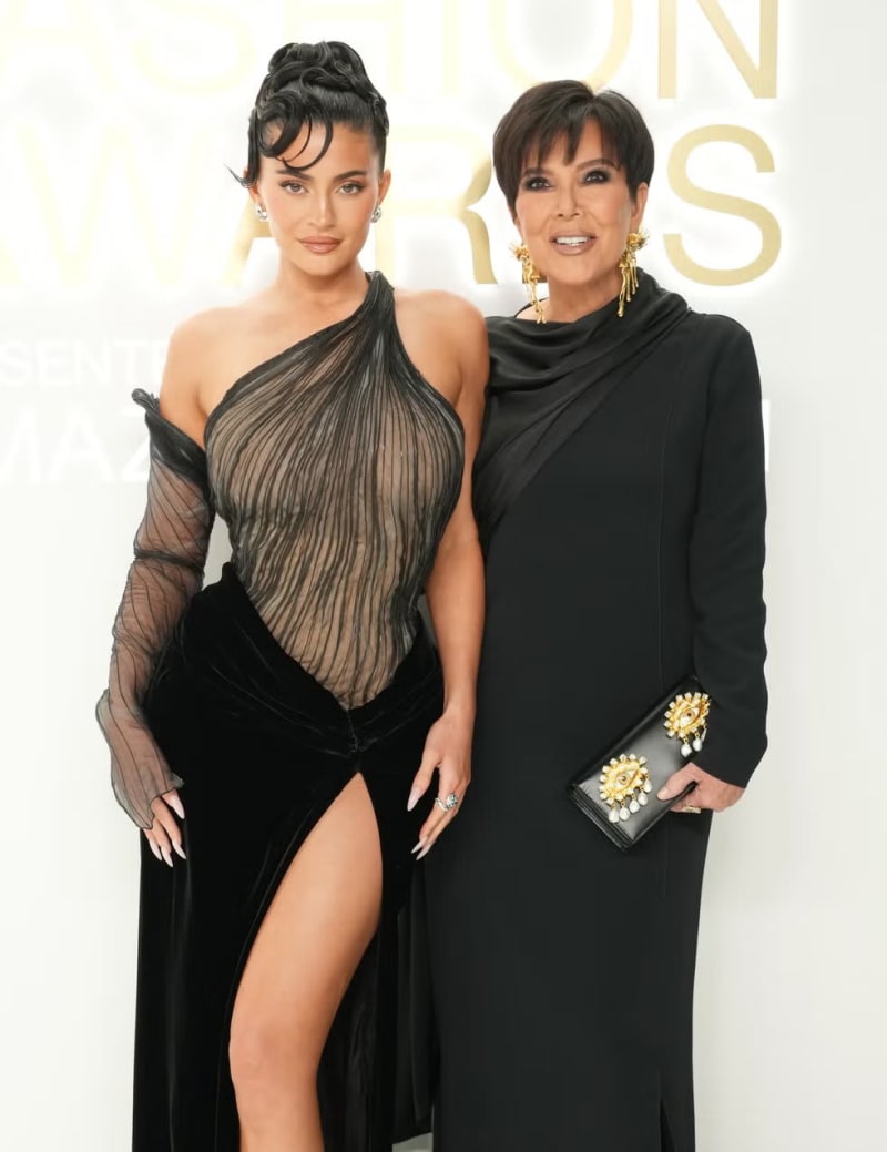 Two women in black gowns posing together at a fashion awards event.