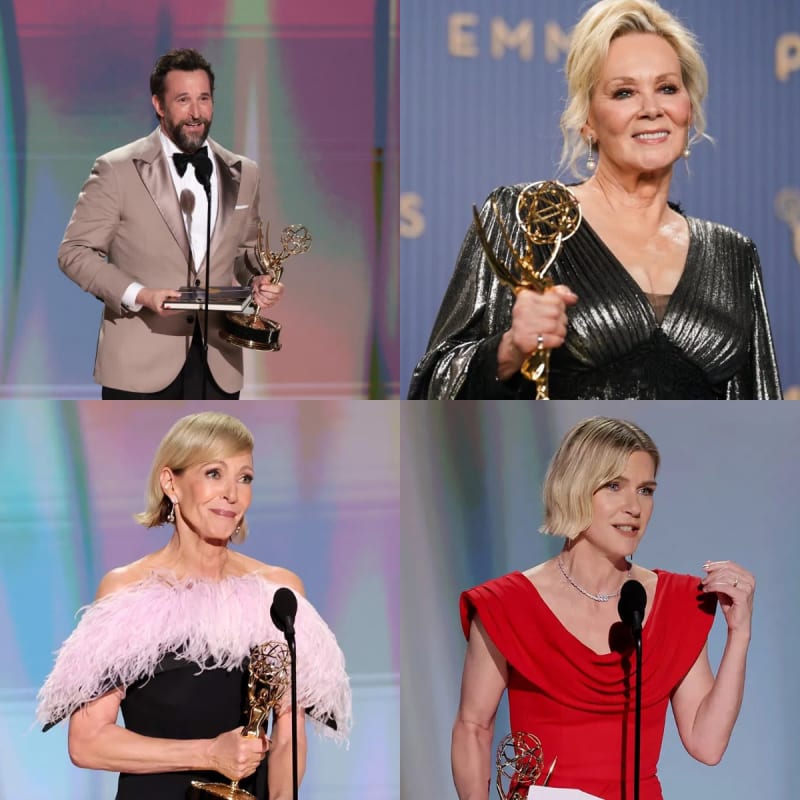 Four Emmy winners at podium: man in tan tuxedo; woman in silver gown; woman in black dress with pink feathers; woman in red dress — all holding Emmy statuettes.