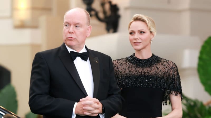 Two people in formal attire at an elegant event; man in black tuxedo with bow tie, woman in black beaded dress.