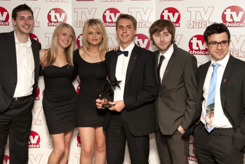Six people in formal attire holding a star-shaped award at a TV Choice event.