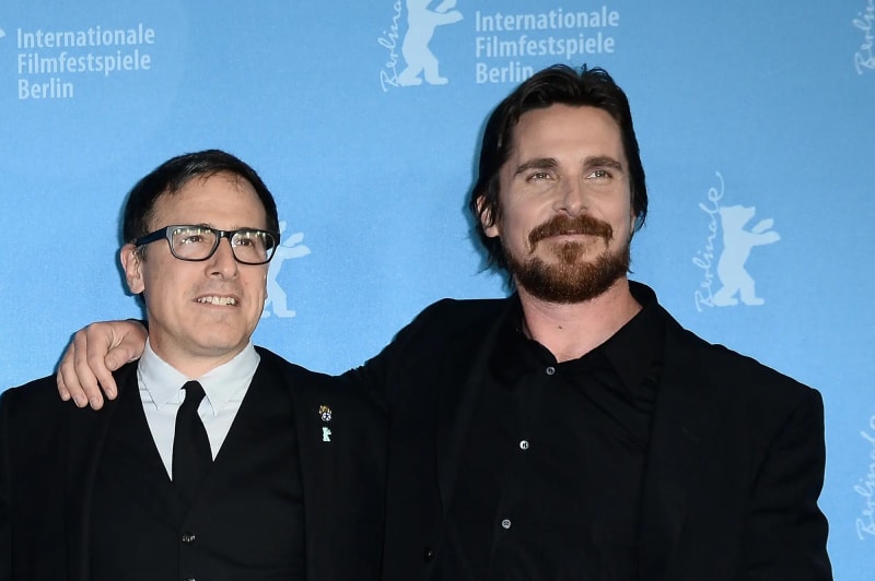 Two men in black suits posing at Internationale Filmfestspiele Berlin backdrop.