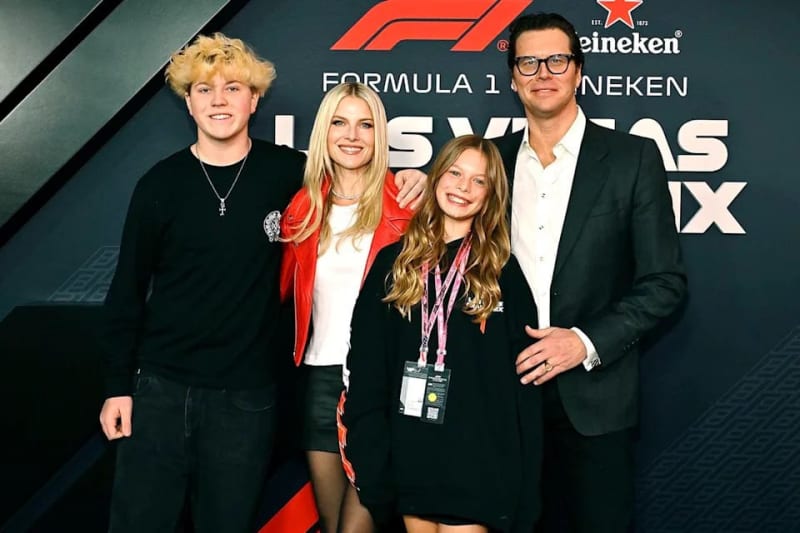 Five people pose together at a Formula 1 Heineken event, with the backdrop displaying the F1 logo and event branding.