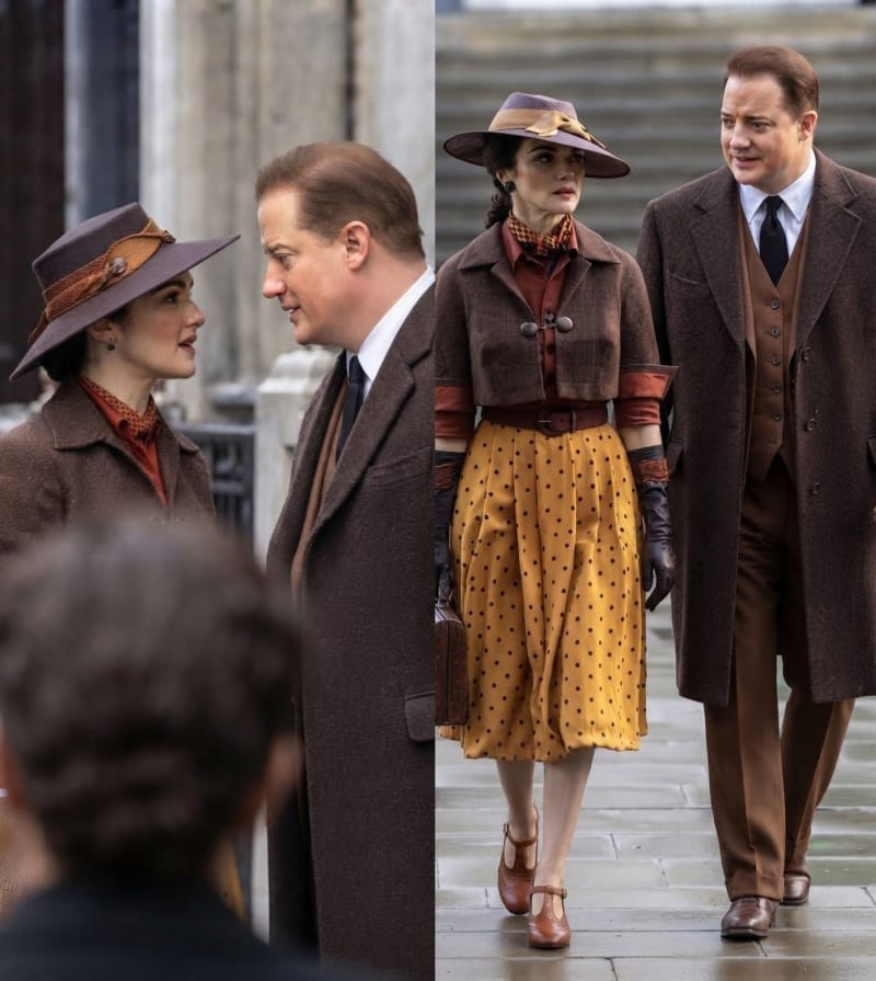 Two on-set photos: woman in brown hat and coat facing man in brown suit; woman in yellow polka-dot skirt and brown jacket walking with same man on stone steps.