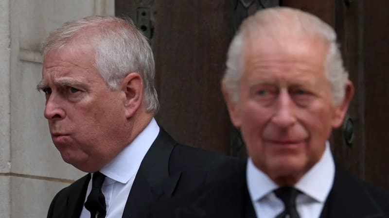Two elderly men in formal black suits and ties standing outside a stone building.