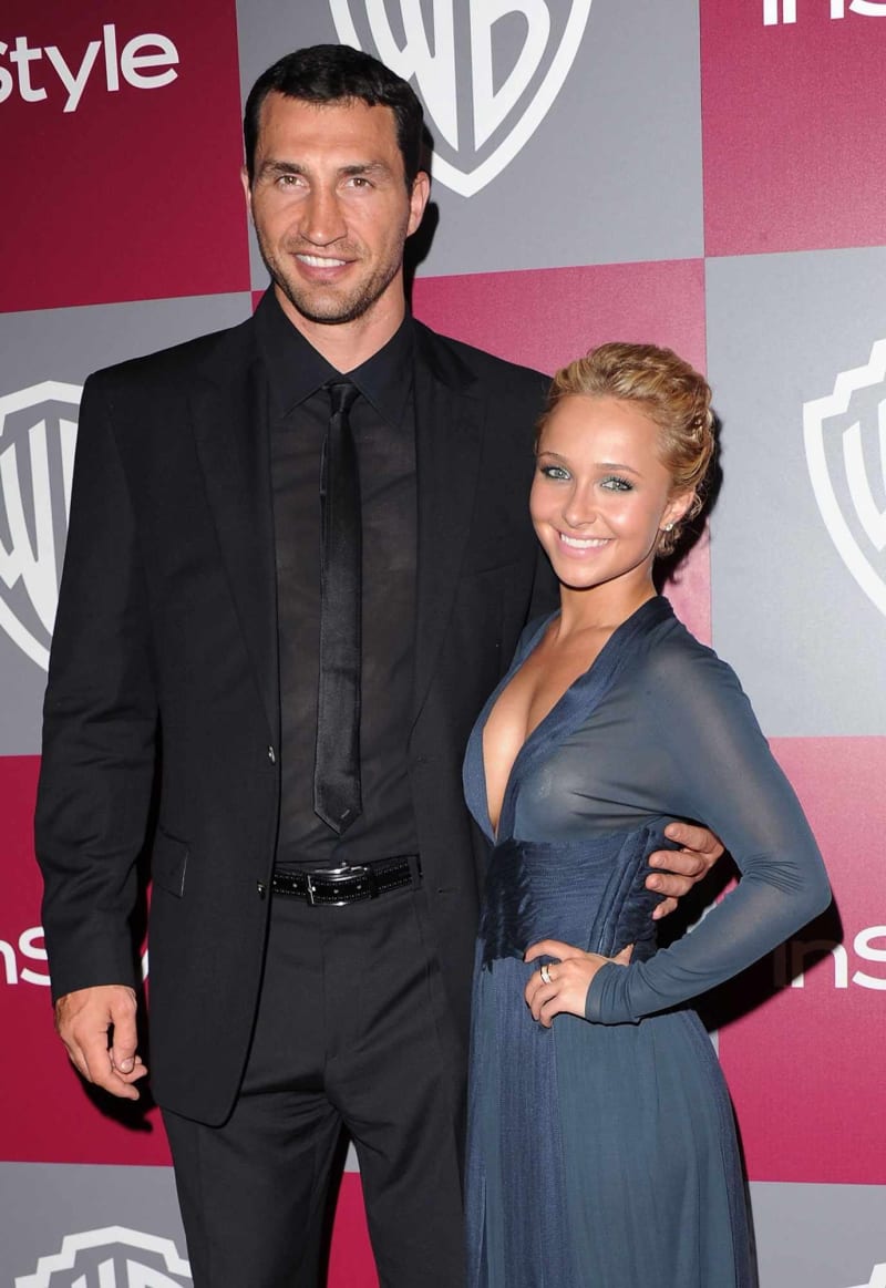 Man in black suit and woman in blue gown posing at InStyle Warner Bros. event.