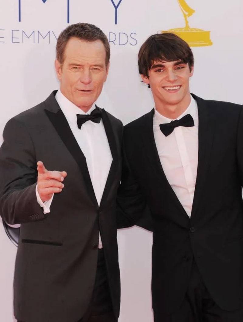 Two men in black tuxedos and bow ties posing at Emmy Awards red carpet.