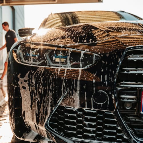 Person applying wax to a blue car