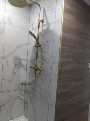 Colonne de douche dorée avec carrelage marbre