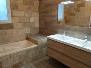 Salle de bain en travertin avec baignoire et double vasque
