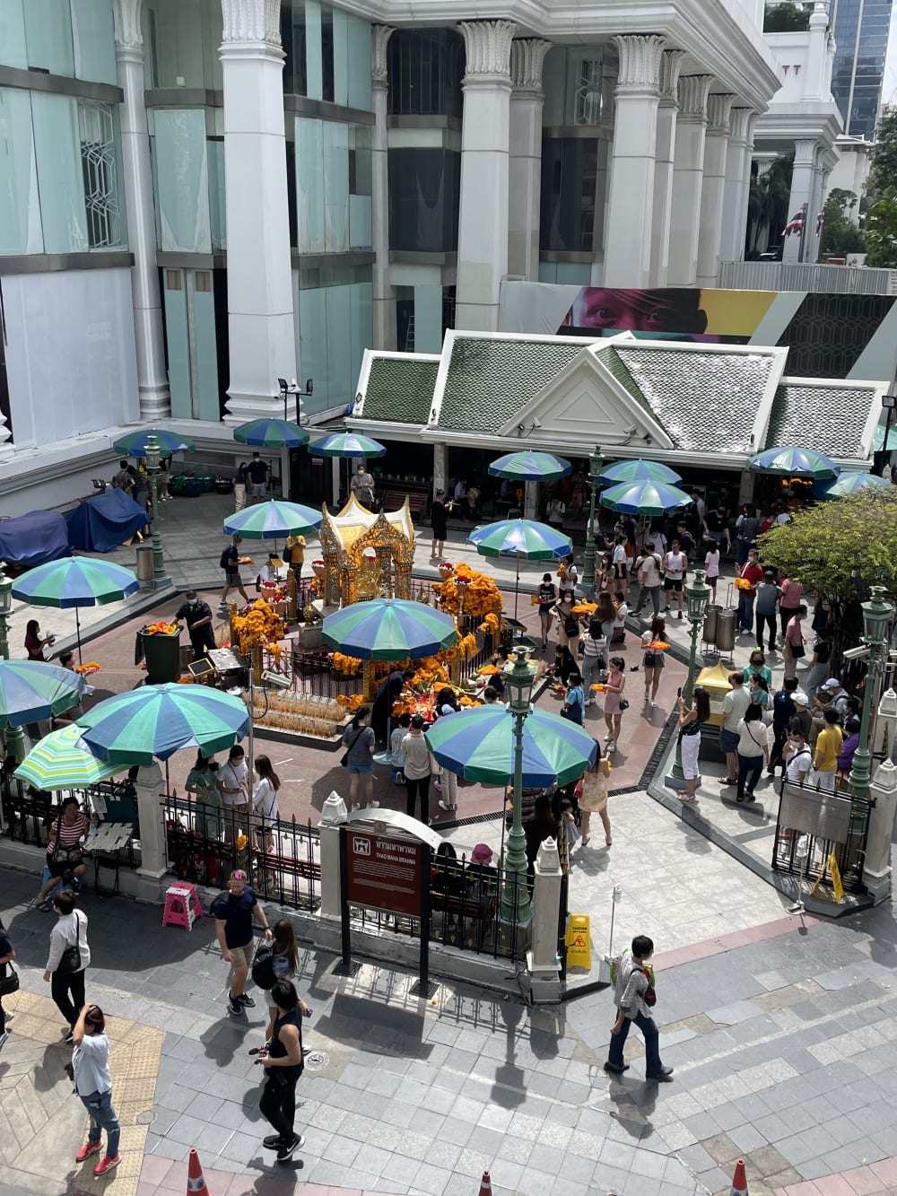 Le sanctuaire d'Erawan et ses parasols, lieu de culte au pied d'un centre commercial à Ratchaprasong, Bangkok
