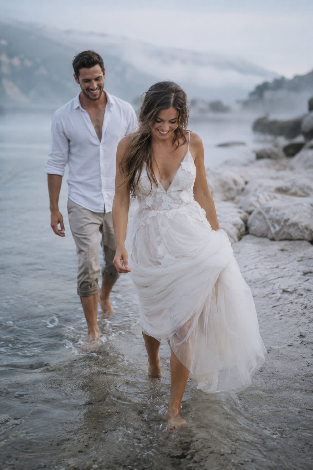 Séance du lendemain au bord de l'eau, la mariée pieds nus dans quelques centimètres d'eau.