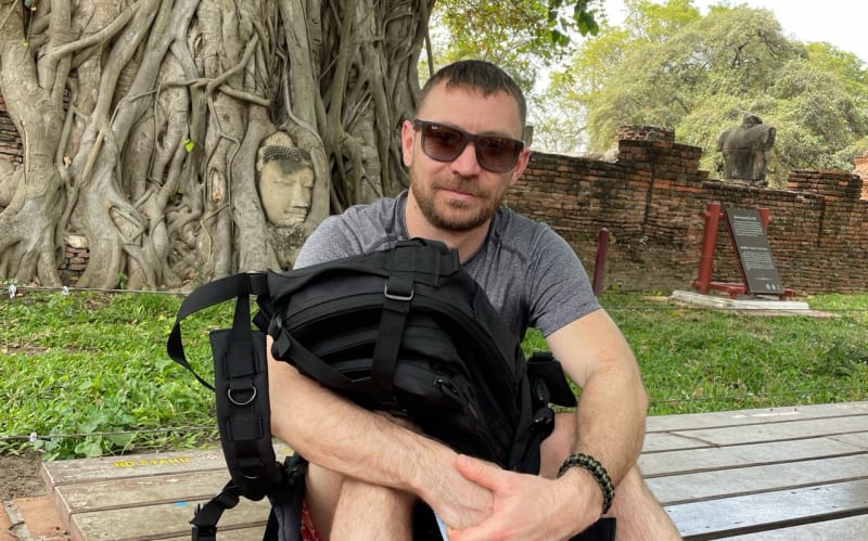 Voyageur avec son sac à dos devant un temple d'Ayutthaya