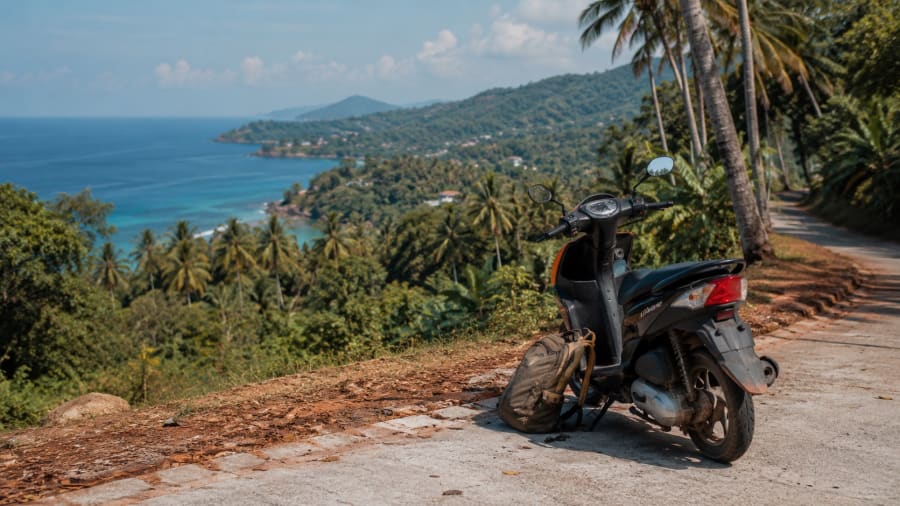 Lifestyle nomade en Thaïlande — scooter sur route côtière tropicale