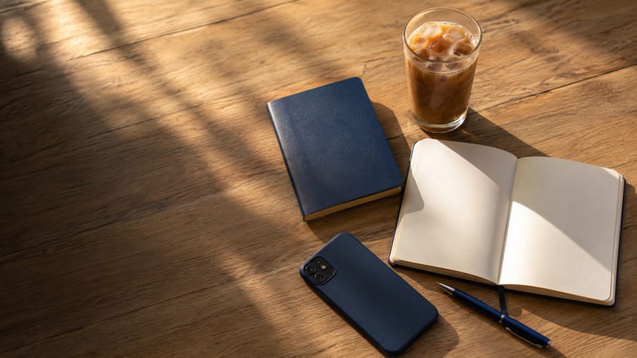 Passeport, carnet et téléphone posés sur une table avant le départ