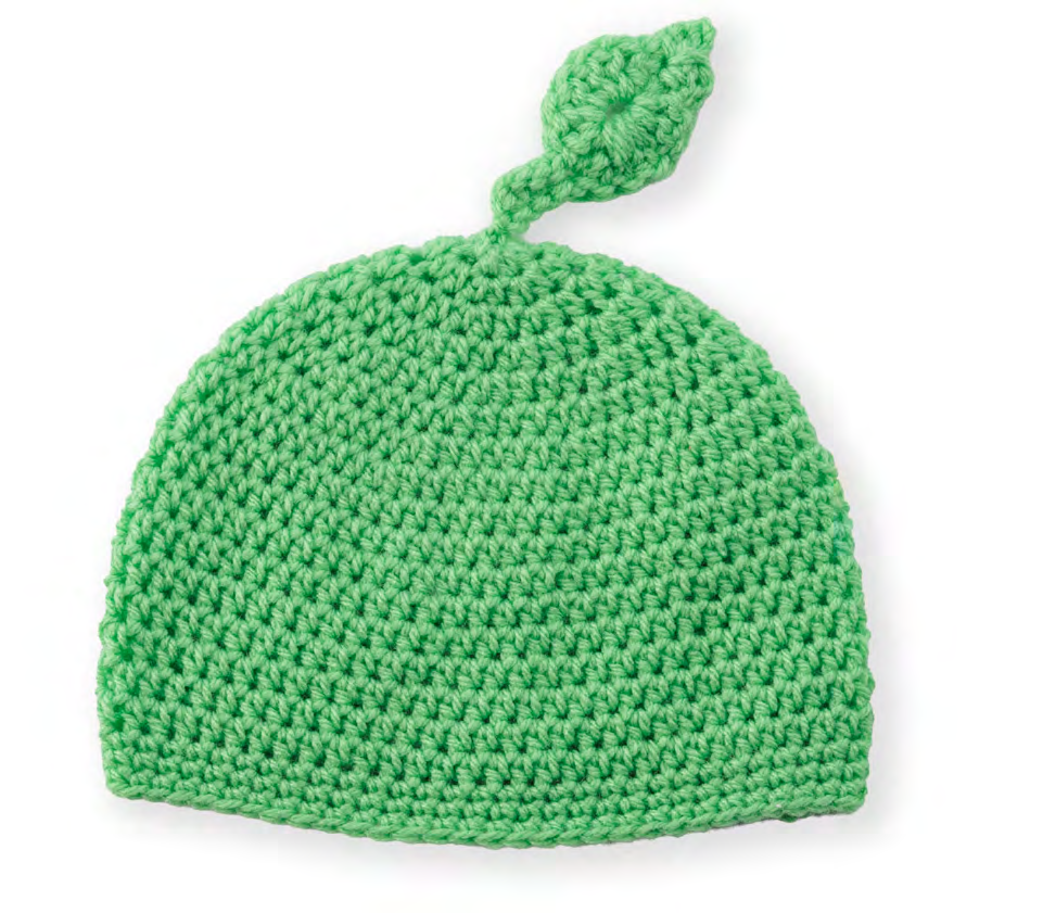 Finished baby hat with leaf on display