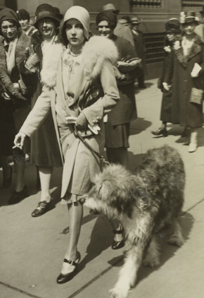 A young woman in 1920s dress smoking while walking in the 1929 New York Easter parade