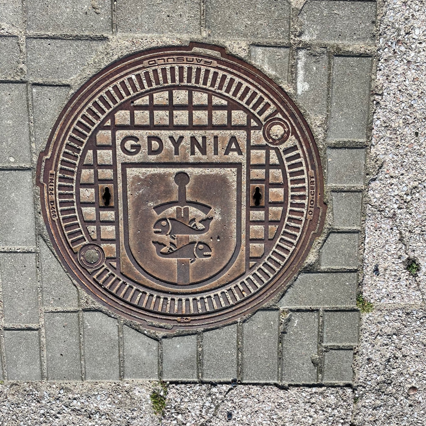 Centrální emblém tohoto exempláře městské infrastruktury, s dvěma stylizovanými rybami na vertikální tyči, jasně odkazuj in Gdynia, Poland — CoverSpot