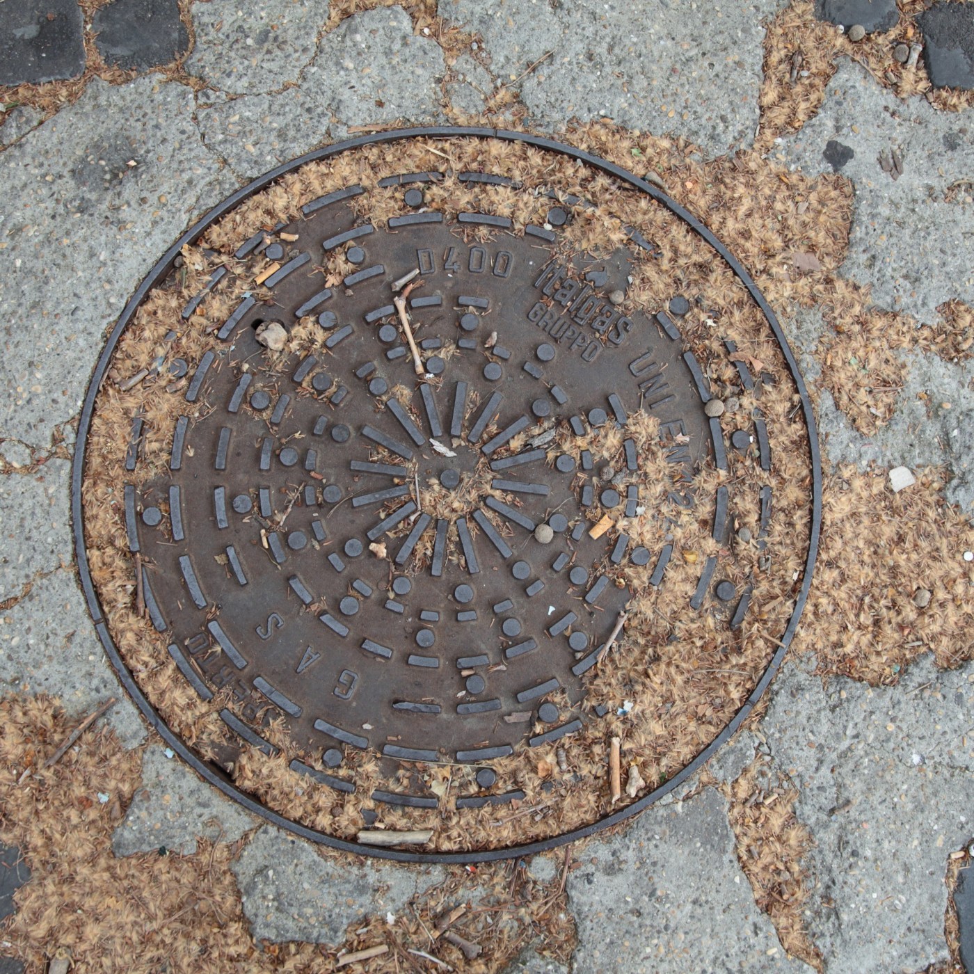 Na tmavém kovovém disku se rozprostírá složitý geometrický vzor tvořený obdélníkovými a kruhovými výstupky, které jsou č in Rome, Lazio, Italy — CoverSpot