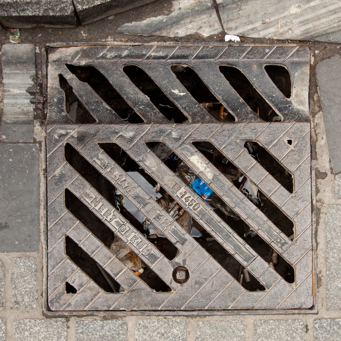 Robustní diagonální mřížkový vzor dominuje tomuto čtvercovému litinovému exempláři, jehož povrch je poznamenán dlouholet in Istanbul, Turkey — CoverSpot
