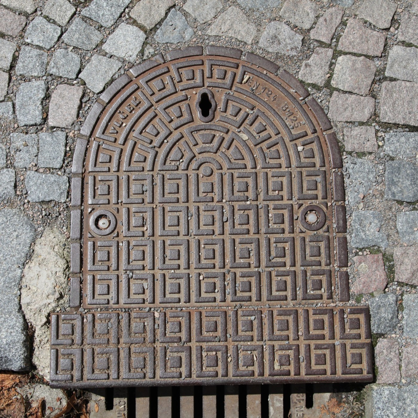 Na povrchu tohoto exempláře litinové infrastruktury dominuje složitý geometrický vzor, který se skládá z opakujících se  in Litomyšl, Czechia — CoverSpot