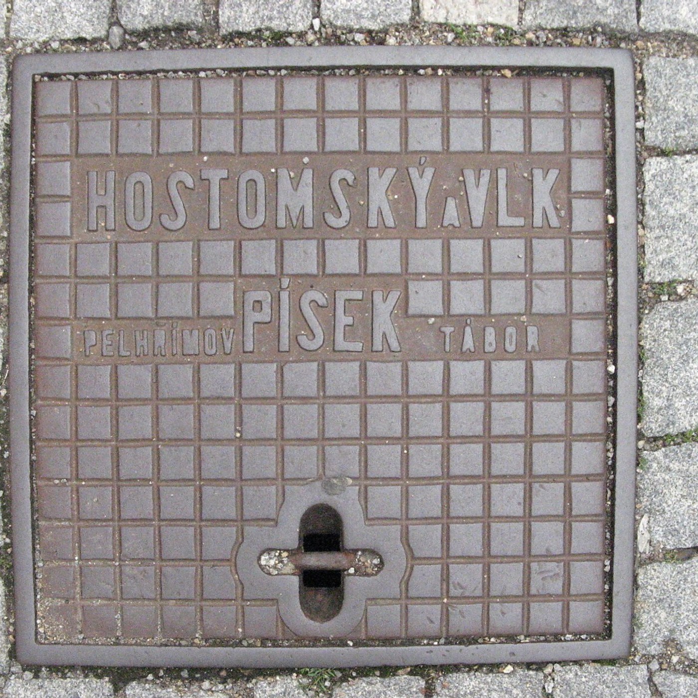 Mřížkový vzor pokrývá celou plochu tohoto exempláře, s výraznými reliéfními nápisy odkazujícími na české lokality. Robus in Písek, Czechia — CoverSpot