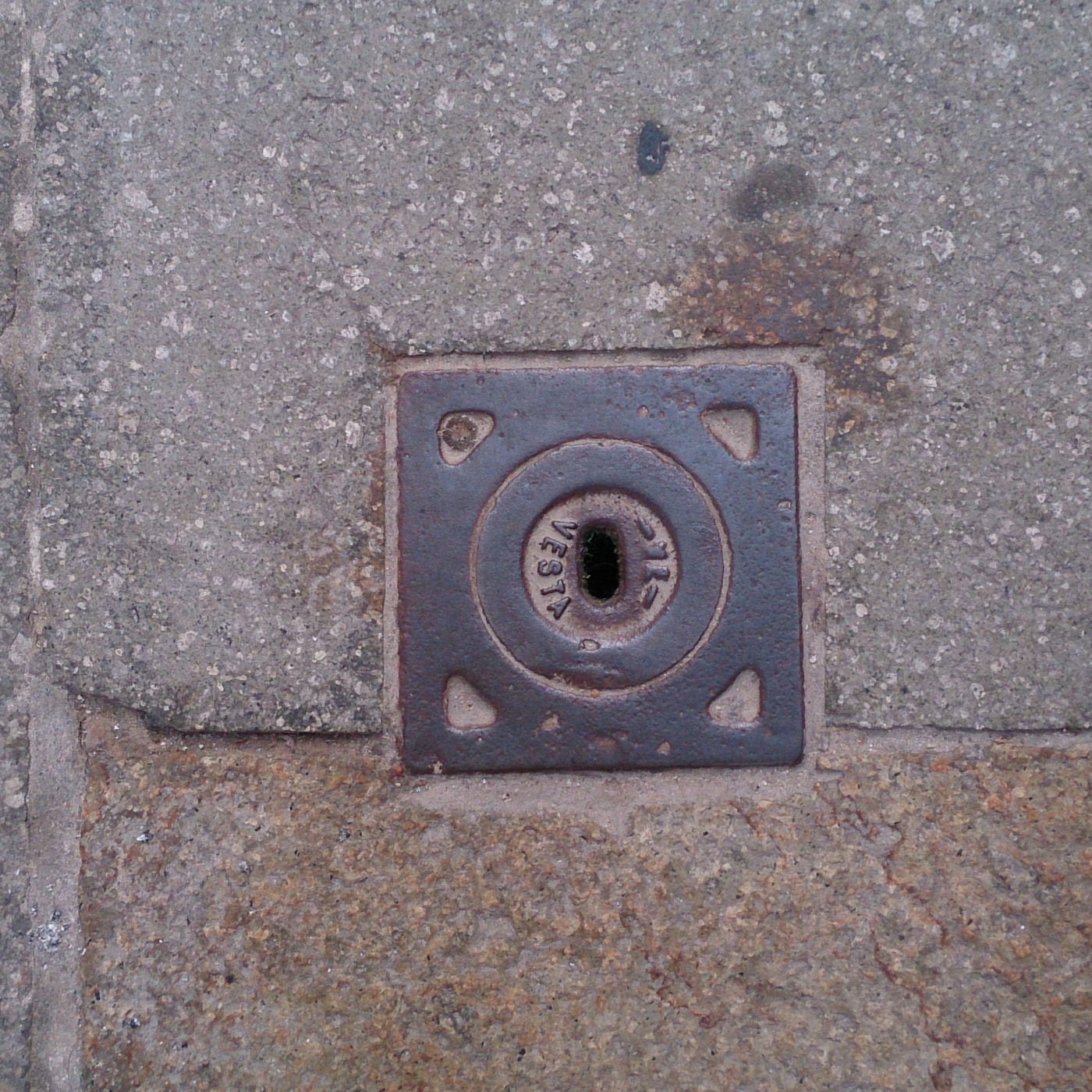 Centrální kruhový prvek, obklopený robustním čtvercovým rámem, nese v sobě ryté nápisy 'VESTA' a '213'. Tento artefakt,  in Venice, Italy — CoverSpot