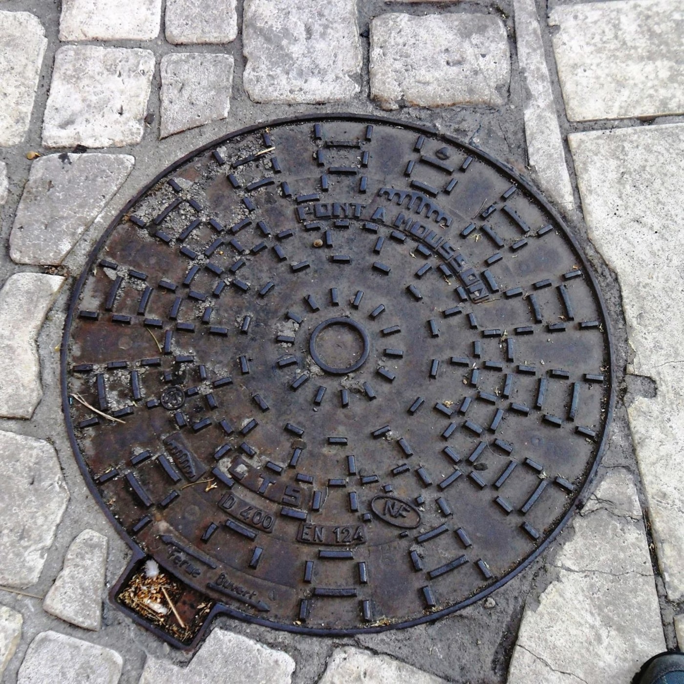 Centrální kruhový prvek, z něhož radiálně vychází vzor krátkých obdélníkových výstupků, dominuje tomuto exempláři městsk in Orange, France — CoverSpot
