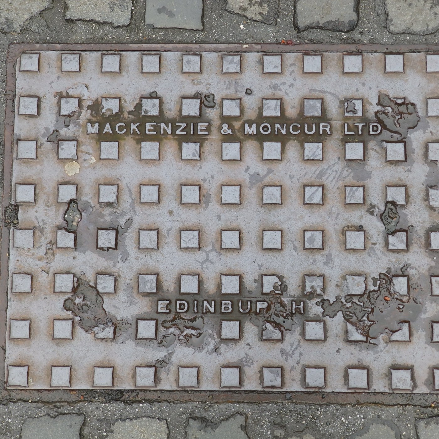 Pravidelný mřížkový vzor s vyvýšenými čtvercovými prvky dominuje tomuto povrchu, což je typické pro rané inženýrské kons in Edinburgh, SCT, United Kingdom — CoverSpot